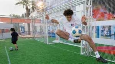 Abdulla Afghani, right, from Afghanistan, teaches freestyle football to a youngster at the Mubadala Football Experience Zone outside Marina Mall.