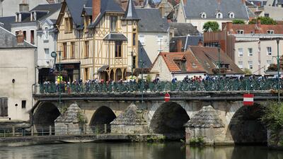 The peloton passes on the Voltaire Bridge over the Canal de Berry in Vierzon. EPA