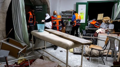 Palestinians clear the damaged furniture from the mosque compound. Reuters