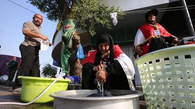 Iraqi women volunteer to wash the clothes of protesters by hand during continuing protests in central Baghdad against corruption, unemployment and appalling public services on November 12, 2019. Security forces in recent days have sought to crack down on rallies demanding regime change in Iraq, but protesters have kept up the movement with sit-ins across the capital and Shiite-majority south. / AFP / SABAH ARAR