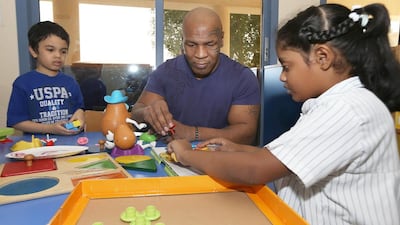 Former American boxer Mike Tyson plays with children at the Dubai Autism Centre during his visit. Pawan Singh / The National