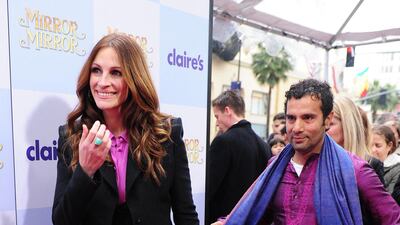 Julia Roberts, in a three-piece suit and contrasting shirt, and Tarsem Singh arrive for the premiere of 'Mirror Mirror' at Grauman's Chinese Theatre in Hollywood, California, on March 17, 2012. AFP