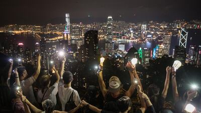 Pro-democracy protesters form a human chain and wave laser pointers, phones and lanterns in the air on Victoria Peak in Hong Kong, China. Getty