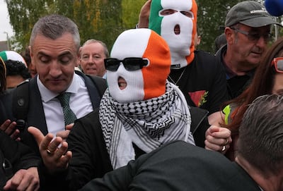Members of Kneecap including rapper Mo Chara, centre. wearing Irish-flag balaclavas outside court in London in September. AFP