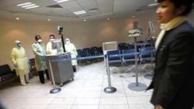 Health officials scan incoming passengers at Abu Dhabi International Airport with an infrared device designed to see if someone has a fever.