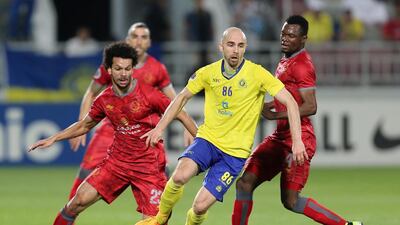 Al-Nassr's Adrian Mierzejewski (C) dribbles past Lekhwiya's Mohammed Tresor (R) and Ahmed Abdul Maqsoud (L) during their AFC Champions League football match at Abdullah Bin Khalifa Stadium in Doha, on April 5, 2016. (AFP)