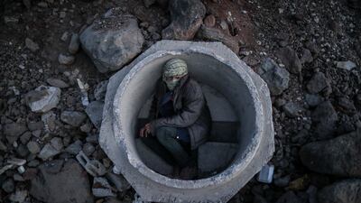 An Afghan boy hides in a sewer pipe near Van city after crossing the Iran-Turkey border. EPA