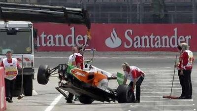 Workers remove the crashed car of Italian Formula One driver Vitantonio Liuzzi of Force India during the qualifying session.