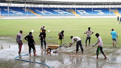 Ground staff try in vain to dry the pitch ahead of the UAE's World League 2 match against Scotland on Wednesday.