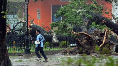 A resident runs past an uprooted tree in Cebu City. AFP Photo