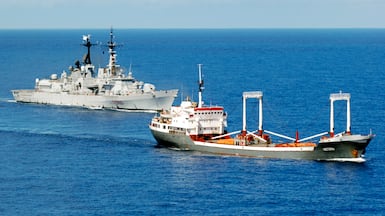 An Italian destroyer escorts a merchant vessel near Somalia. A similar convoy operation could be launched in the Strait of Hormuz. Reuters