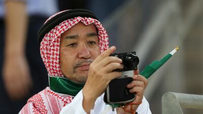 A Japanese fan wears Saudi traditional clothes takes a picture during the 2018 World Cup group B qualifying soccer match between Saudi Arabia and Japan in Jiddah, Saudi Arabia, Tuesday, Sept. 5, 2017. (AP Photo)