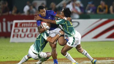 Fale So'oialo of Samoa, centre, is tackled during the Sevens World Series match between Samoa and South Africa on Friday in Dubai. Jake Badger for The National