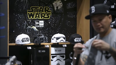 Store manager Jun Concepcion organizes the merchandise at New Era, a new store selling the latest Star Wars memorabilia at the Al Wahda Mall in Abu Dhabi. Silvia Razgova / The National