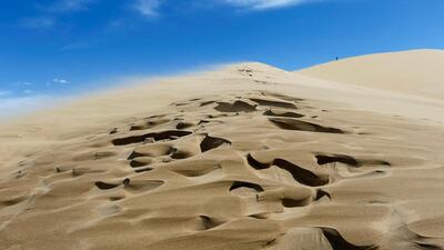 A tourist stands on top of the Singing Sands. Shamil Zhumatov / Reuters