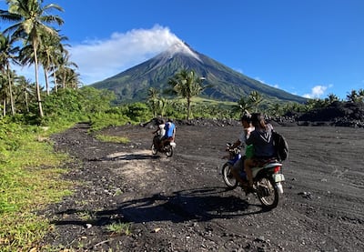 Farmers on motorcycles in the danger zone as Mayon volcano spews ashes and lava in Daraga. EPA