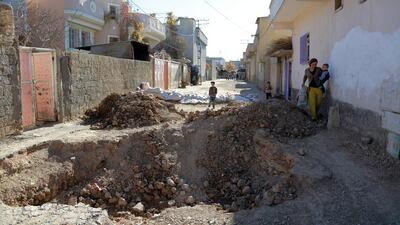 People walk through the destroyed barricades set up by the militants of the Kurdistan Workers' Party, or PKK, in Nusaybin, Turkey on December 25, 2015. Murat Bay / AP Photo