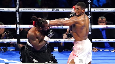 Jermaine Franklin, right, punches Anthony Joshua during a heavyweight boxing match at The O2. AP