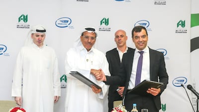 Khalaf Ahmad Al Habtoor (second from left), founding chairman of Al Habtoor Group, shaking hand with Amnon Shashua, chief executive of Mobileye, after signing the pact. Courtesy Al Habtoor Group