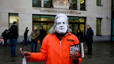 A protester wearing a Julian Assange mask, poses for a photograph as they support the Wikileaks founder outside Westminster Magistrates Court. AFP