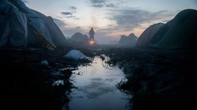 A woman stands by the fire at sunrise in a transit camp for migrants and refugees on the Greek side of the Greek-Macedonian border near Idomeni, Greece. Thousands of migrants intending to reach western European countries are stranded in Greece as Slovenia, Croatia, Serbia and Macedonia have introduced special measures allowing migrants to enter their countries only according to the Schengen rules. Zoltan Balogh / EPA