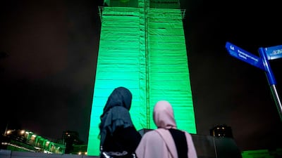 Members of the public hold a vigil near Grenfell Tower in West London to honour the people who died when a fire ripped through the tower block. AFP