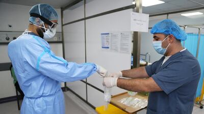 A doctor wearing protective gear handles a coronavirus test sample at Rafik Hariri University Hospital in Beirut, Lebanon. The pandemic has put the country's healthcare system in crisis, officials said on January 2, 2020. Reuters