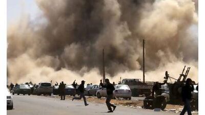 Libyan rebels take cover as a bomb dropped by a fighter jet explodes near a checkpoint on the outskirts of Ras Lanuf in March. Marco Longari / AFP