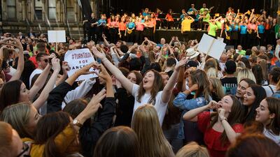 A group of young women sing and dance during the Manchester Together - With One Voice tribute concert at Albert Square. Leon Neal/Getty Images