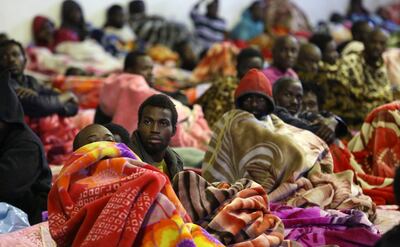 A picture taken on December 11, 2017 shows African migrants sitting and lying in a shelter at the Tariq Al-Matar migrant detention centre on the outskirts of the Libyan capital Tripoli. AFP