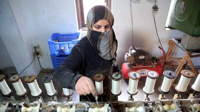 A Kashmir labourer works inside a silk factory on the outskirts of Srinagar. EPA