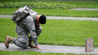 US Army Reserve Sgt Edwin Morales kneels as he honors his cousin Ruben Correa during the ceremonies at the National 9/11 Memorial and Museum in New York. Reuters