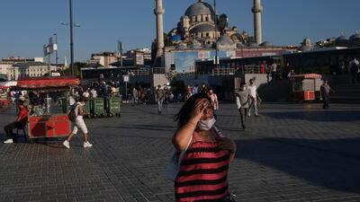 A woman walks in front of the Yeni Mosque at the Eminonu Square, amid the ongoing coronavirus pandemic in Istanbul, Turkey. EPA