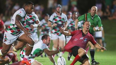 Abu Dhabi Harlequins pull down a Dubai Exile player and then pursue the ball during their win on Friday night. Mona Al Marzooqi / The National