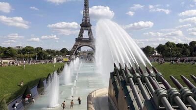 Tourists cool off in the fountains across the river from the Eiffel Tower in Paris. The French government said in August that visits by all foreigners had dropped by 7 per cent in the period from January. Regis Duvignau / Reuters
