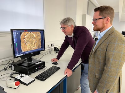 Professor Paul N Pearson, UCL, left, and Jesper Ericsson, The Hunterian, University of Glasgow look at the Sponsian gold coin under a microscope. Photo: The Hunterian, University of Glasgow