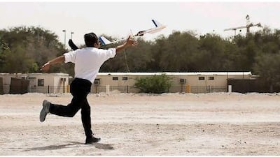 A Northrop Grumman employee demonstrates how to launch a model aeroplane before a competition for students in Abu Dhabi.