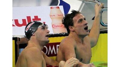 Ryan Lochte, right, and fellow American Scott Clary look up to see Lochte’s record-breaking time in the pool in Dubai last night.