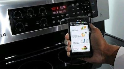 A smartphone sends instructions to an oven using LG's Smart ThinQ technology. Ethan Miller / Getty