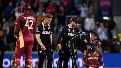 West Indies all-rounder Carlos Brathwaite is consoled by New Zealand players after defeat on Saturday. Clive Mason / Getty Images