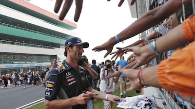 Red Bull driver Mark Webber distributes his autographs to fans at the Buddh International Circuit ahead of the Indian Grand Prix on Thursday. Adnan Abidi / Reuters