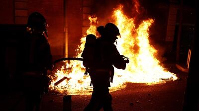 Firefighters extinguish items set on fire by protesters in Madrid. EPA