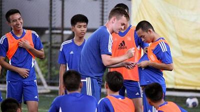 Josh McEachran signs autograph for Thai youths during a coaching clinic in Bangkok. Apichart Weerawong / AP Photo