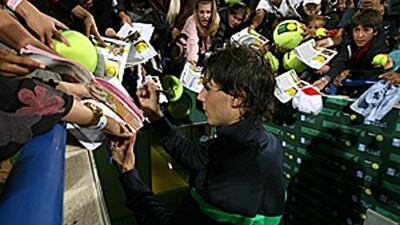 Rafael Nadal, who beat David Ferrer in straight sets last night, signs autographs on the second day of the Capitala tournament.