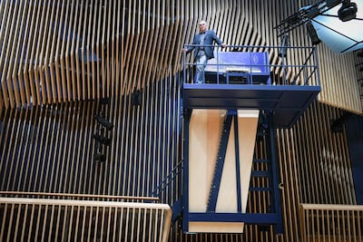 Piano constructor and builder David Klavins stands next to his new creation, the M470i vertical concert grand piano. AFP