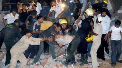 Rescue workers clear the rubble, during an operation searching for survivors at the site of the collapsed apartment building in down town Alexandria, Egypt, early Wednesday, Oct. 8, 2008.