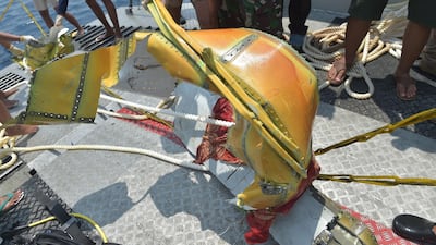 Members of the Indonesian Navy place parts of the ill-fated Lion Air flight JT 610 onto the deck of their ship during search operations at sea. AFP