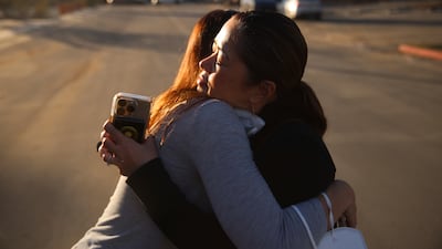 Pasadena Park Healthcare and Wellness Center chief Amy Johnson, left, hugs Rhea Bartolome, vice president of operations, outside their centre. AP