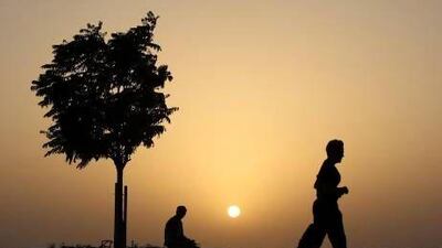 A jogger running along the Corniche as the sun sets In Abu Dhabi.