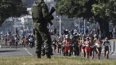 Competitors run along the road as a Brazilian soldier patrol the course during the women’s marathon race of the Rio 2016 Olympic Games in Rio de Janeiro, Brazil, 14 August 2016. Antonio Lacerda / EPA